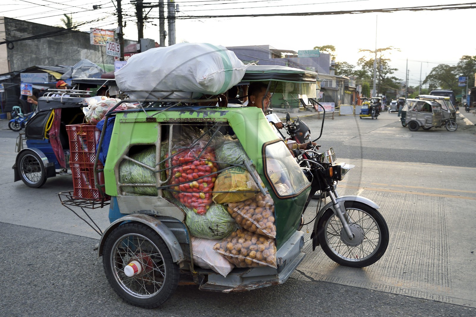 Philippines, province de Nueva Ecija, Bambang, transport de marchandises en tricycle motorisé dans la rue principale