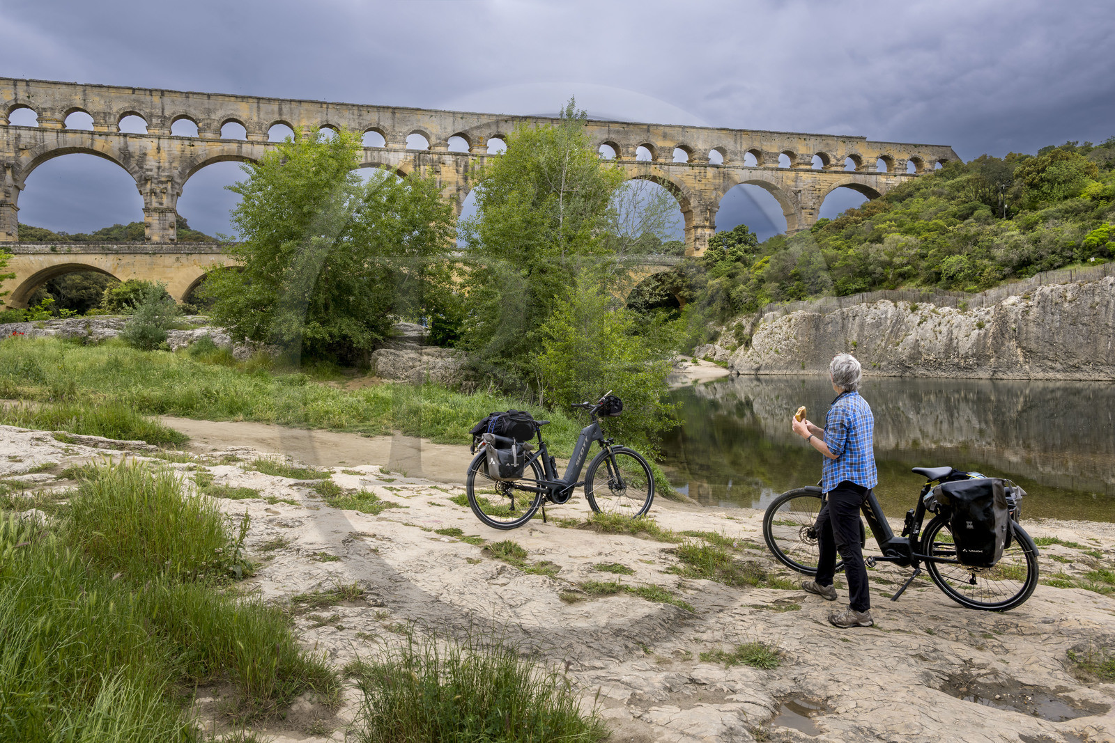 France, Gard (30), le Pont du Gard classé Patrimoine Mondial de l'UNESCO, Grand Site de France, cycliste prenant une pause devant le pont aqueduc romain qui enjambe le Gardon
