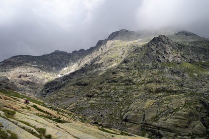 France, Alpes-Maritimes (06), parc national du Mercantour, Vallée des Merveilles parsemée de milliers de gravures rupestres de l'Age de bronze, randonneurs attroupés autour de la roche dite du Sorcier sur les dalles de schiste jaune des chiappes et le Mont Bégo en arrière plan