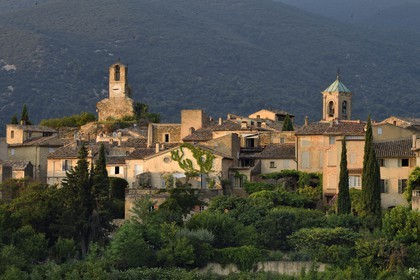France, Vaucluse (84), Parc Naturel Regional du Luberon, Lourmarin, labellisé Les Plus Beaux Villages de France, la Tour de l'horloge et le chocher de l'église, le massif du Lubéron en arrière-plan